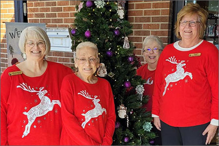 Library Staff in Matching Christmas Sweaters by the Tree